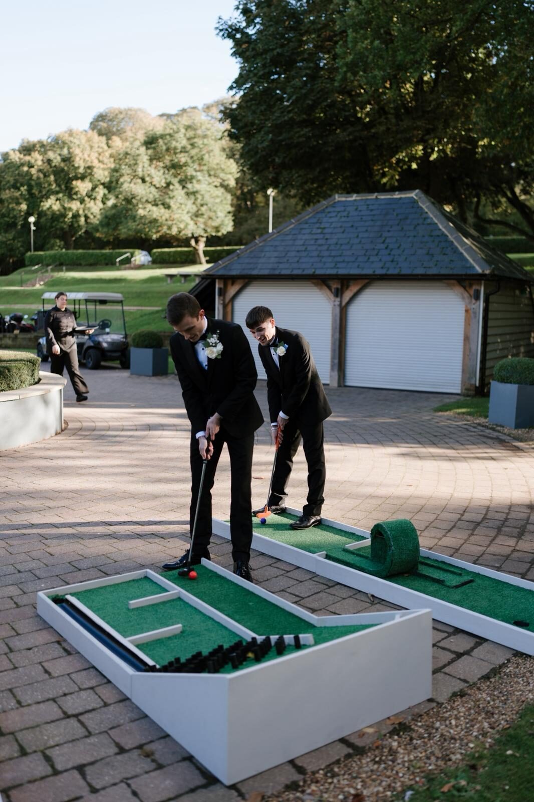 Groomsmen playing crazy golf at a wedding venue